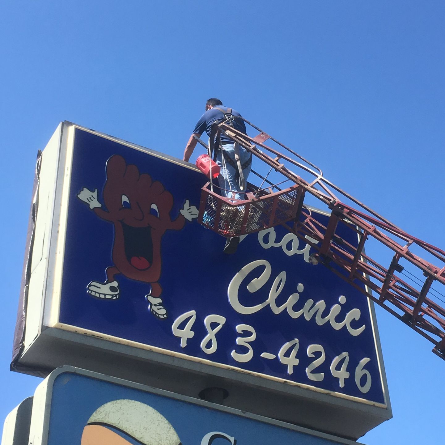 Worker prepares to remove the Happy Foot Sad Foot Sign